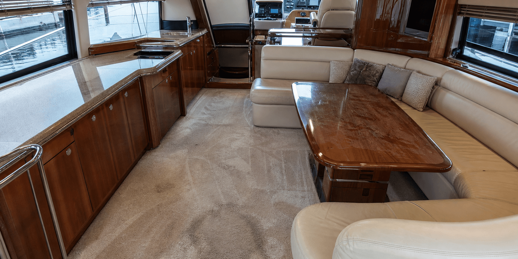 Before interior yacht cleaning: used yacht salon with light clutter and visible traffic marks