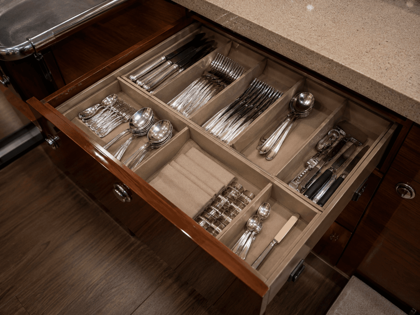 Organized yacht galley drawer with clean utensils and onboard accessories