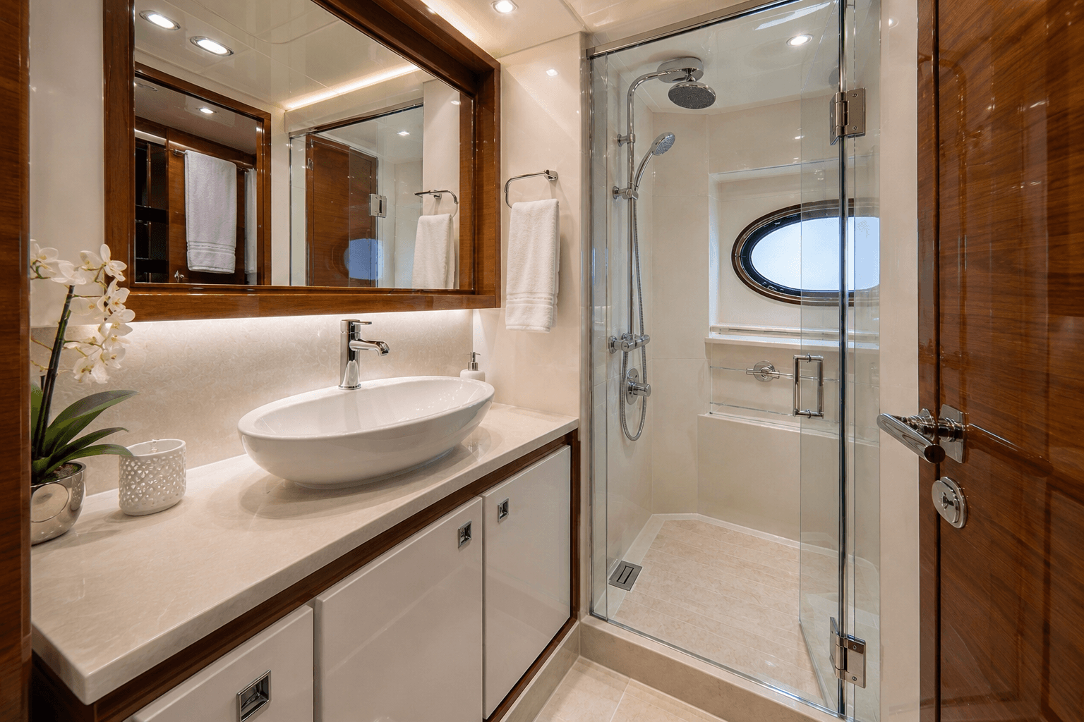 Spotless yacht head and shower with polished fixtures and clean glass